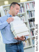 Man carrying a precarious stack of books. Стоковое фото, агентство Ingram Publishing / Фотобанк Лори