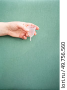 Hands holding menstrual cup over violet background, eco friendly and zero waste solution. Menstrual cap over violet background. Стоковое фото, агентство Ingram Publishing / Фотобанк Лори
