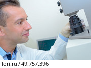 Technician adjusting lens of microscope. Стоковое фото, агентство Ingram Publishing / Фотобанк Лори