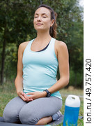 smiling woman kneelt in meditative yoga position. Стоковое фото, агентство Ingram Publishing / Фотобанк Лори