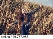 A young woman expresses her sheer joy while surrounded by a beautiful cornfield, dancing playfully and carefree amidst the tall golden stalks under a stunningly clear blue sky filled with sunshine. Joyful Dance in a Golden Cornfield, celebrating the beauty of nature and carefree moments. Стоковое фото, агентство Ingram Publishing / Фотобанк Лори