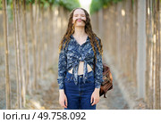A playful and vibrant young woman poses confidently on a beautiful scenic pathway, showcasing her unique and trendy fashion sense while exuding her joyful and freespirited personality. A Joyful Young Woman Embracing Nature with Her Unique Fashion Style and Playful Attitude. Стоковое фото, агентство Ingram Publishing / Фотобанк Лори