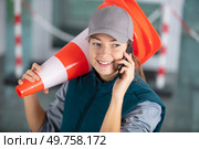 happy female builder holding traffic cone. Стоковое фото, агентство Ingram Publishing / Фотобанк Лори