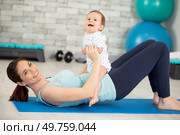 young mother does physical exercises with her baby. Стоковое фото, агентство Ingram Publishing / Фотобанк Лори