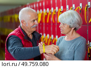 senior woman securing locker ket bracelet to husbands wrist. Стоковое фото, агентство Ingram Publishing / Фотобанк Лори