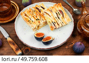 Filo pastry cakes with figs and cheese. Delicious autumn homemade dessert.. Delicious filo pastry dessert on a wooden board. Стоковое фото, агентство Ingram Publishing / Фотобанк Лори