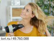 young woman drying her hair with electric blowdryer. Стоковое фото, агентство Ingram Publishing / Фотобанк Лори