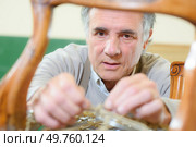 Repairing a damaged chair. Стоковое фото, агентство Ingram Publishing / Фотобанк Лори