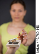 woman reaching for cigarette on mousetrap. Стоковое фото, агентство Ingram Publishing / Фотобанк Лори