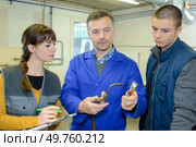 ironworks teacher showing students how to securely use gas welder. Стоковое фото, агентство Ingram Publishing / Фотобанк Лори