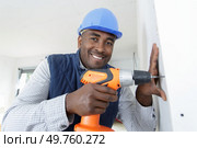 happy man drills a wall with a drill. Стоковое фото, агентство Ingram Publishing / Фотобанк Лори