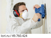 a young builder sanding wall. Стоковое фото, агентство Ingram Publishing / Фотобанк Лори
