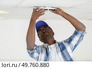 a man fixes ceiling skirting. Стоковое фото, агентство Ingram Publishing / Фотобанк Лори