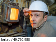 portrait of male worker next to incinerator inspection glass. Стоковое фото, агентство Ingram Publishing / Фотобанк Лори