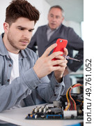 boss is annoyed because young worker is on his smartphone. Стоковое фото, агентство Ingram Publishing / Фотобанк Лори