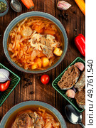 Tasty soup with meat on rustic wooden table. Traditional Ukrainian borscht. Top view.. Soup borshch in bowl, Ukrainian cuisine. Стоковое фото, агентство Ingram Publishing / Фотобанк Лори