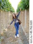 A trendy young woman experiences a whimsical and joyful moment in a stunning vineyard, surrounded by lush and vibrant greenery, creating a captivating scene filled with happiness and delight. A stylish young woman dances joyfully in a scenic vineyard, surrounded by vibrant nature. Стоковое фото, агентство Ingram Publishing / Фотобанк Лори