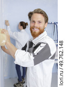 professional man with sponge float plastering white wall. Стоковое фото, агентство Ingram Publishing / Фотобанк Лори