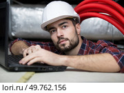 electrician fitting ac hoses in buildings ceiling. Стоковое фото, агентство Ingram Publishing / Фотобанк Лори