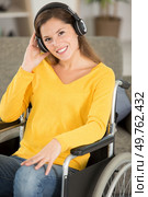 contented woman in wheelchair listening to earphones. Стоковое фото, агентство Ingram Publishing / Фотобанк Лори