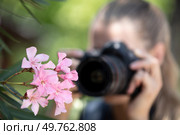 female photographer taking a macro picture of flower. Стоковое фото, агентство Ingram Publishing / Фотобанк Лори