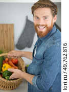 a friendly man with a huge basket of vegetables. Стоковое фото, агентство Ingram Publishing / Фотобанк Лори
