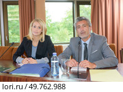 Suited man and woman sat behind desk. Стоковое фото, агентство Ingram Publishing / Фотобанк Лори