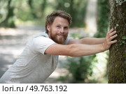 handsome young man leaning against tree. Стоковое фото, агентство Ingram Publishing / Фотобанк Лори