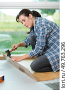 woman installing new laminate wood flooring. Стоковое фото, агентство Ingram Publishing / Фотобанк Лори
