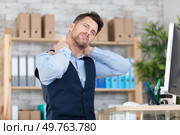 young frustrated freelancer is having a strong pain in neck. Стоковое фото, агентство Ingram Publishing / Фотобанк Лори
