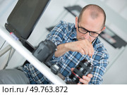 man cleaning and repairing a digital camera lense. Стоковое фото, агентство Ingram Publishing / Фотобанк Лори
