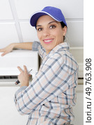 happy repairwoman fixing air conditioner unit. Стоковое фото, агентство Ingram Publishing / Фотобанк Лори