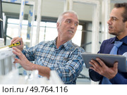 worker using tape-measure in plastic window and door manufacturing factory. Стоковое фото, агентство Ingram Publishing / Фотобанк Лори