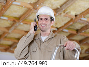 portrait of tradesman using a walkie-talkie while standing on stepladder. Стоковое фото, агентство Ingram Publishing / Фотобанк Лори