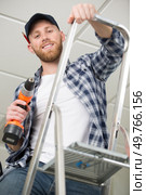 construction worker with power tool on stepladder. Стоковое фото, агентство Ingram Publishing / Фотобанк Лори