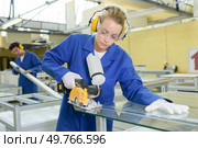 Woman cutting through glass with rotary blade. Стоковое фото, агентство Ingram Publishing / Фотобанк Лори