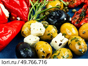 Starter of green olives, black olives, capers, sun dried tomatoes and cheese. Close up. Greek antipasti snacks set. Стоковое фото, агентство Ingram Publishing / Фотобанк Лори