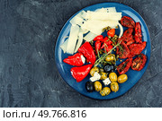 Cheese variety, Mediterranean olives, sun-dried tomatoes, black and green olives and marinated red peppers stuffed with soft cheese. Space for text.. Appetizer antipasti set. Стоковое фото, агентство Ingram Publishing / Фотобанк Лори