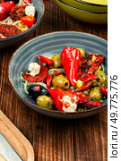 A delicious salad of pickled soybean sprouts, dried tomatoes, olives and peppers on wooden rustic background. Chinese food.. Vegan Salad of Pickled Vegetables and Soybeans. Стоковое фото, агентство Ingram Publishing / Фотобанк Лори