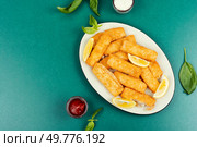 Crumbed fried fish fingers in sticks with sauce. Restaurant menu, cookbook recipe. Space for text.. Cod fish nuggets. Стоковое фото, агентство Ingram Publishing / Фотобанк Лори