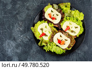 Funny monster face on Halloween sandwich toast. Halloween. Copy space.. Mini sandwiches with monster faces. Стоковое фото, агентство Ingram Publishing / Фотобанк Лори