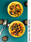 Ratatouille or stewed potatoes, eggplants, zucchini, onions, carrots in spicy sauce with greens.. Delicious vegetable stew in a bowl on the table. Стоковое фото, агентство Ingram Publishing / Фотобанк Лори