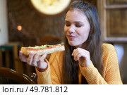 A woman delights in savoring a freshly made sandwich, truly embodying the joy that comes from good food served in a warm, inviting atmosphere that significantly enhances her overall experience. Delightfully savoring a freshly made sandwich while relaxing in a cozy and warm setting. Стоковое фото, агентство Ingram Publishing / Фотобанк Лори