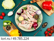 Raw uncooked chicken legs or drumsticks with spices, meat with ingredients for cooking. Top view.. Raw chicken leg pieces with spices. Стоковое фото, агентство Ingram Publishing / Фотобанк Лори
