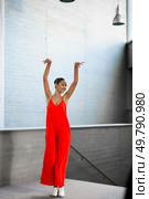 A dancer in a vivid red outfit strikes a captivating pose, showcasing her talent in a contemporary setting, embodying grace and dynamic movement while radiating effortless energy that draws all eyes. An Elegant Dancer Dressed in Vibrant Red Attire Poses Beautifully in a Modern Interior. Стоковое фото, агентство Ingram Publishing / Фотобанк Лори