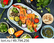 Uncooked, raw salmon slice with herbs and spices on plate on table. Ingredients for cooking. Flat lay.. Raw salmon steak. Стоковое фото, агентство Ingram Publishing / Фотобанк Лори