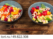 Refreshing salad featuring shrimp and tropical fruit mix on wooden surface.. Tasty seafood salad and exotic fruits. Стоковое фото, агентство Ingram Publishing / Фотобанк Лори