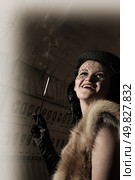 attractive girl holding mouthpiece with cigarette in glove-covered hand. Стоковое фото, агентство Ingram Publishing / Фотобанк Лори