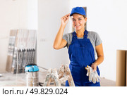 Portrait of positive builder woman in blue overalls next to stepladder. Стоковое фото, фотограф Яков Филимонов / Фотобанк Лори