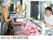 Polite young saleswoman weighting piece of meat. Стоковое фото, фотограф Яков Филимонов / Фотобанк Лори